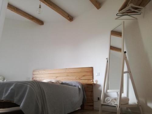 a bedroom with a bed with a wooden headboard and a mirror at Il Silos in Maccarese