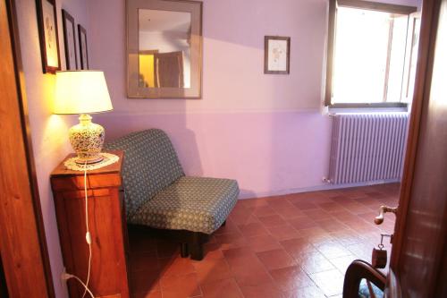 a room with a chair and a lamp on a table at Malvarina in Capodacqua
