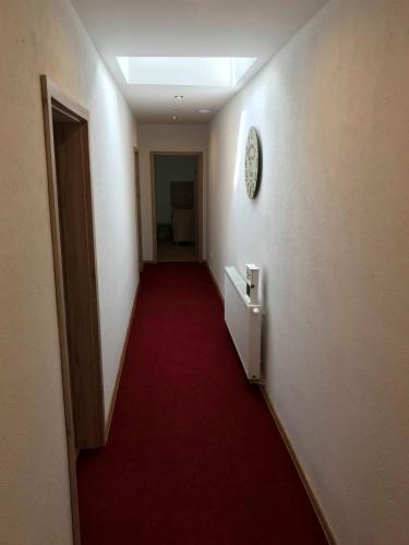 a hallway with a red carpet and a stairway at Ubytovanie MI - TATRY in Kravany