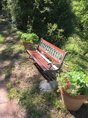 a wooden bench sitting next to some potted plants at Rent House Orahovo in Virpazar