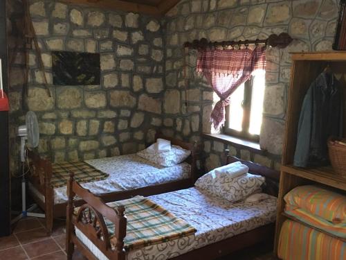 a small room with two beds and a window at Rent House Orahovo in Virpazar