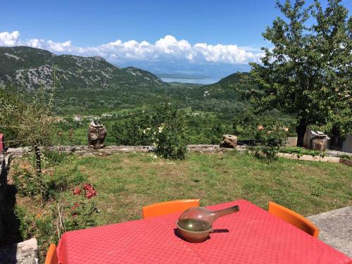 a red table with a bell on top of it at Rent House Orahovo in Virpazar
