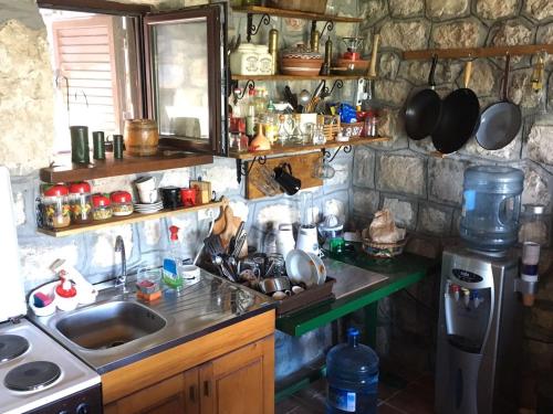 a kitchen with a sink and a counter with pots and pans at Rent House Orahovo in Virpazar