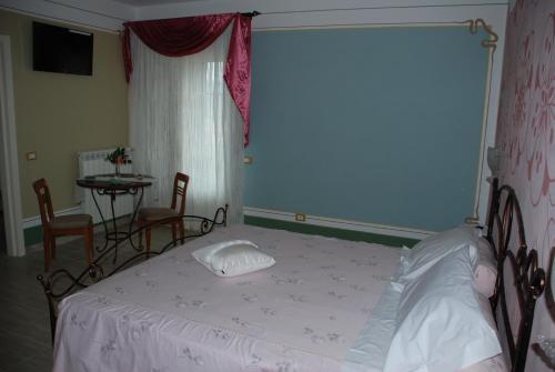 a bedroom with a bed and a table and a window at La Chandelle in Massarosa