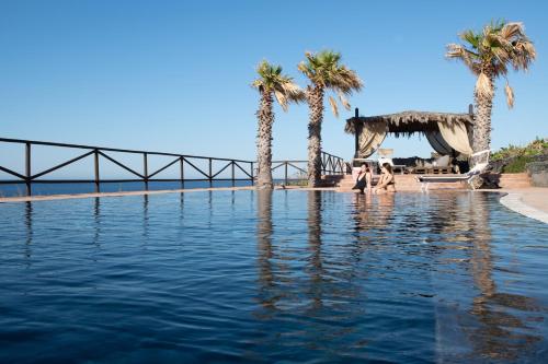 una piscina di acqua con palme e scivolo di Hotel Bue Marino a Pantelleria