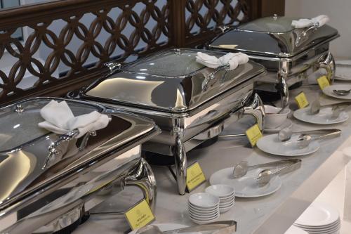 two silver trays with plates and cups on a table at Garco Dragon Hotel 2 in Hanoi