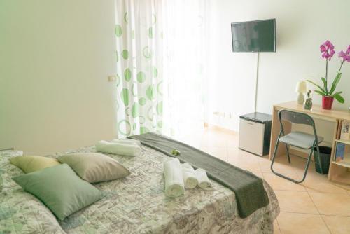 een slaapkamer met een bed met kussens en een bureau bij B&B Alle Falde Dell'Etna in Zafferana Etnea