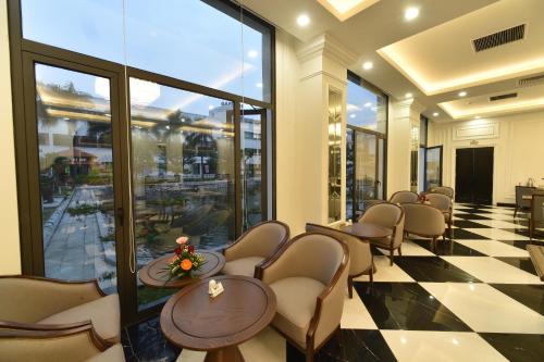 a waiting room with chairs and tables and windows at Garco Dragon Hotel 2 in Hanoi
