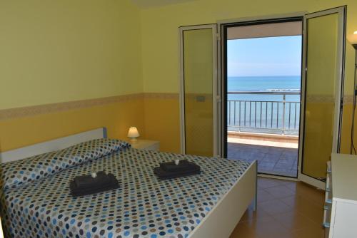 una camera con letto e vista sull'oceano di Casa Donna Titina a Punta Secca