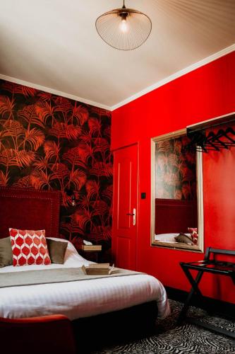 a red bedroom with a bed and a red wall at La villa 10 HÔTEL SPA in Étretat
