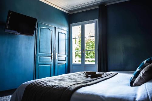 a blue bedroom with a bed and a window at La villa 10 HÔTEL SPA in Étretat