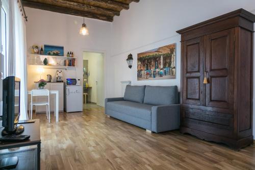 uma sala de estar com um sofá e uma cozinha em Corte del Merlo em Palermo
