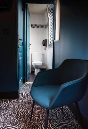 a blue chair in a bathroom with a toilet at La villa 10 HÔTEL SPA in Étretat