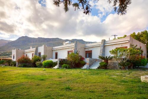 a building with a grass field in front of it at Amatu Villa (Athena) in Xerokampos