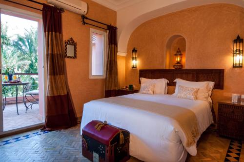 een slaapkamer met een groot bed en een groot raam bij Double room in a charming villa in the heart of Marrakech palm grove in Marrakesh