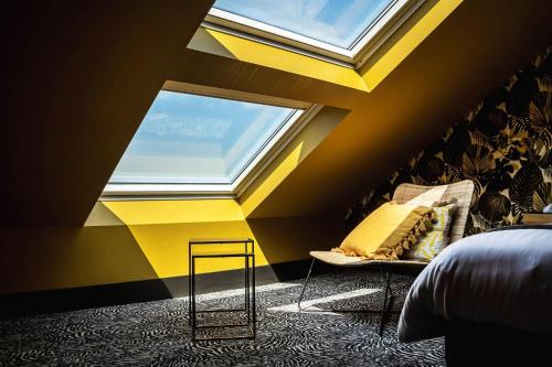 a bedroom with yellow and yellow walls and a window at La villa 10 HÔTEL SPA in Étretat
