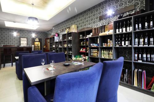 un ristorante con sedie blu, tavolo e bottiglie di vino di Hotel Corona a Kaplice