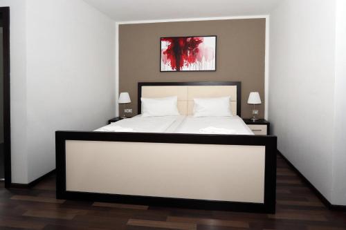 a bedroom with a large white bed with two lamps at Hotel Corona in Kaplice
