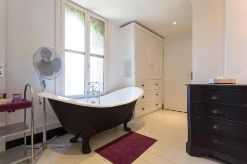 La salle de bains est pourvue d'une grande baignoire et d'une fenêtre. dans l'établissement La Petite Fontaine, à Théoule-sur-Mer