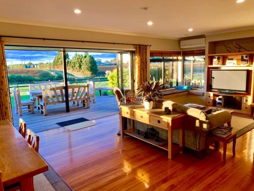 ein Wohnzimmer mit einem Sofa und einem TV in der Unterkunft Heaven's Rest B&B in Pukekohe East