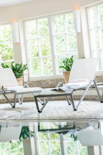 two white chairs sitting in a room with windows at Dorint Strandresort & Spa Westerland/Sylt in Westerland (Sylt)