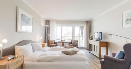 a living room with a white couch and a table at Dorint Strandresort & Spa Westerland/Sylt in Westerland (Sylt)