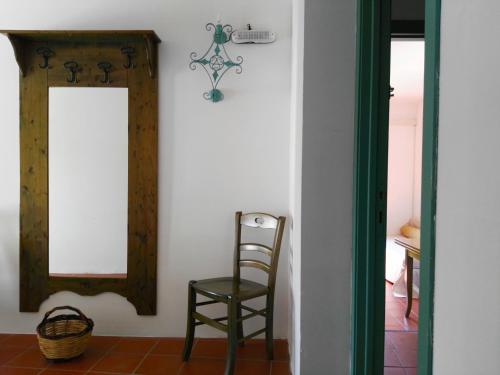 a chair and a mirror in a room at Agriturismo Francesca Stajano in Alezio