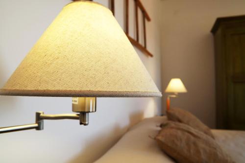 a lamp attached to a wall next to a bed at Agriturismo Francesca Stajano in Alezio