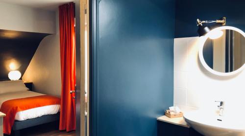 a bathroom with a bed and a sink and a mirror at Hotel Linette in Aumont-Aubrac