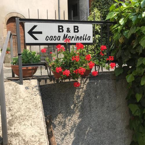 a sign for a flower shop with flowers and plants at Bed & Breakfast Casa Marinella in Lenna