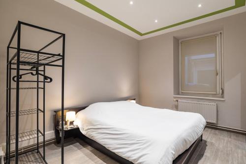 - une chambre avec un lit blanc et une étagère noire dans l'établissement CityCosy Strasbourg - Modern Family Deserte, à Strasbourg