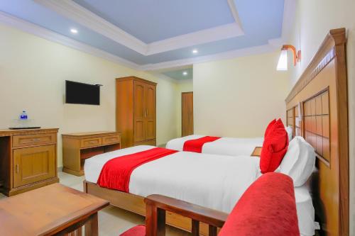 Cette chambre comprend deux lits et une télévision. dans l'établissement Hotel Lacoul Inn, à Siddharthanagar