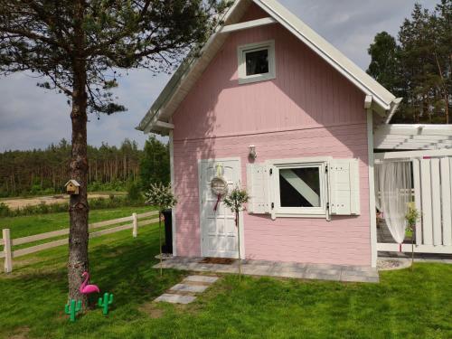 a pink house with a tree in the yard at Bajkowy domek Villa Rosa na Kaszubach in Grzybowo