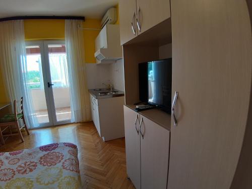 a small room with a bed and a television in it at Apartments and Rooms Dobrila in Jelsa