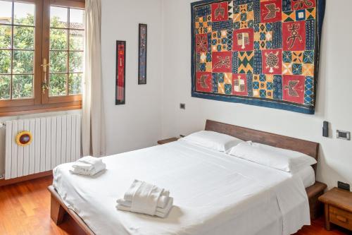 una camera da letto con un letto bianco con due asciugamani sopra di Casa Nespolo Abano Terme ad Abano Terme