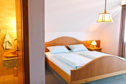 a bedroom with a bed and a bathroom with a tub at Zum Bräu-Toni in Dietfurt