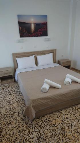 a bedroom with a large bed with two towels on it at Firaxenia rooms in Fira