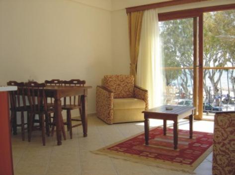 ein Wohnzimmer mit einem Tisch und Stühlen sowie ein Esszimmer in der Unterkunft Oasis Apart in Turgutreis