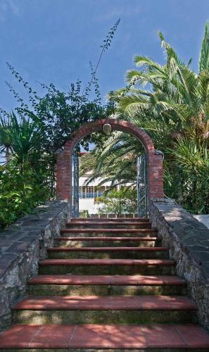 a brick stairway with an archway and some trees at La Chandelle in Massarosa