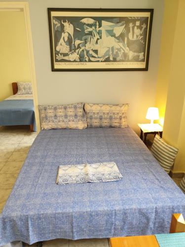 a bedroom with a bed with a blue comforter at Tolis Apartments in Preveza