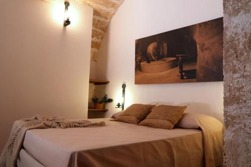 a bedroom with a bed with a painting on the wall at Agriturismo Francesca Stajano in Alezio