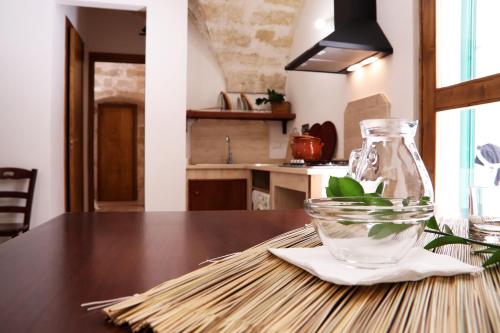 a table with a glass jar and a vase on it at Agriturismo Francesca Stajano in Alezio