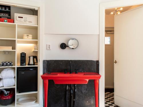 a red table in a room with a shelf at SWEETS - Van Hallbrug in Amsterdam