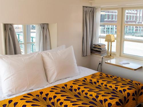 een slaapkamer met een bed met een zwarte en gele deken bij SWEETS - Van Hallbrug in Amsterdam
