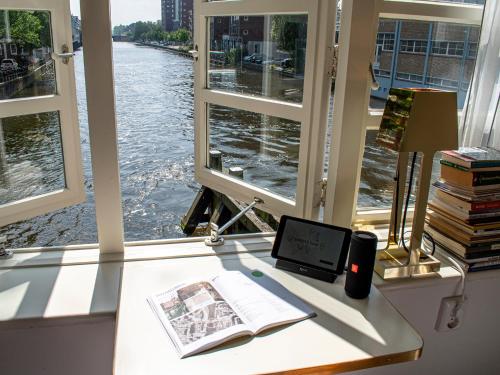 a desk with a book and a tablet next to a window at SWEETS - Van Hallbrug in Amsterdam