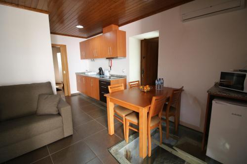 a kitchen with a dining room table and a couch at Cascata do Varosa - Turismo Rural in Vila Pouca