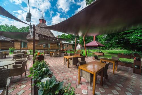a patio with tables and chairs and a building at Aquadar in Manʼkivka