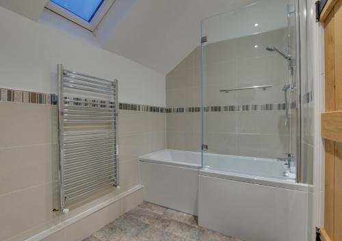 a bathroom with a shower and a bath tub at Cae Bach in Llangelynin