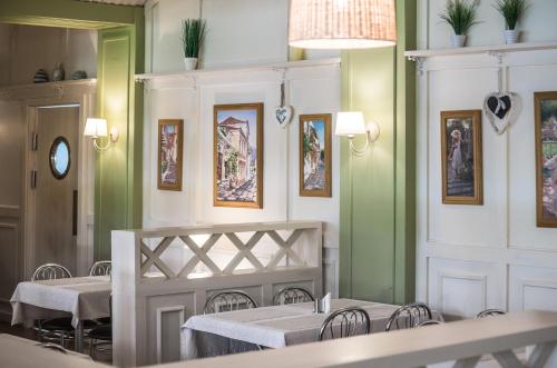 a dining room with tables and chairs and a chandelier at Aquadar in Manʼkivka