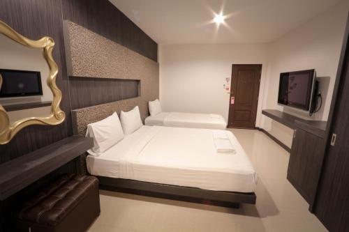a hotel room with a bed and a television at Fortune Surin Hotel in Surin